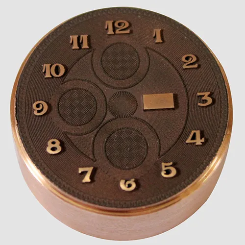 Horology component 2D texturing and raised number engraving on a  bronze watch dial die component using a Minnie laser marking system